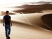 man walking in the desert, looking into the distance.