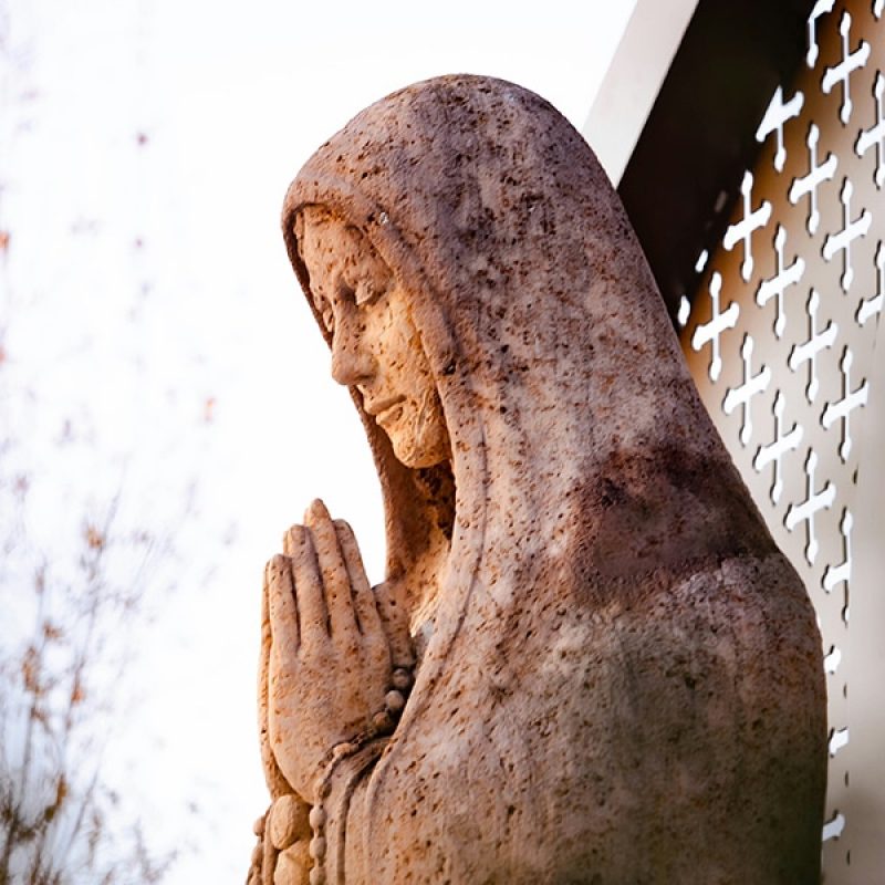 Virgin Mary praying in front of a Church