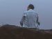 man sitting quiet on a rock in fog