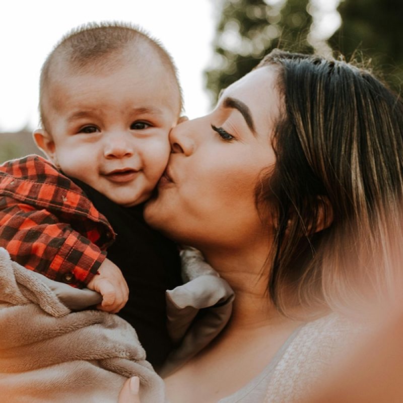 mother giving. baby a kiss