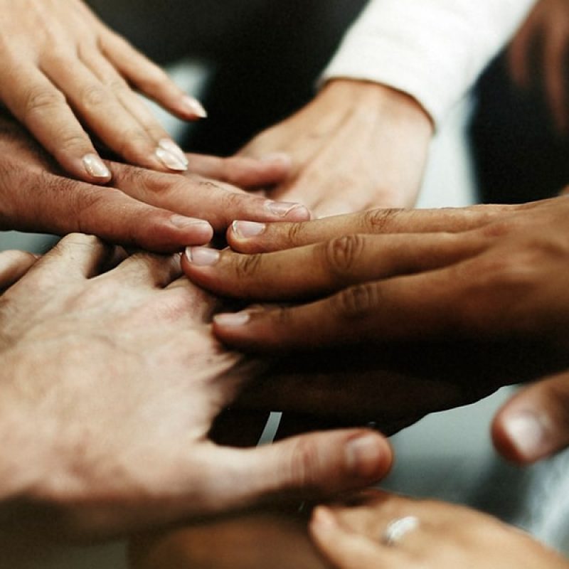 multiple hands touching, connecting with each other.