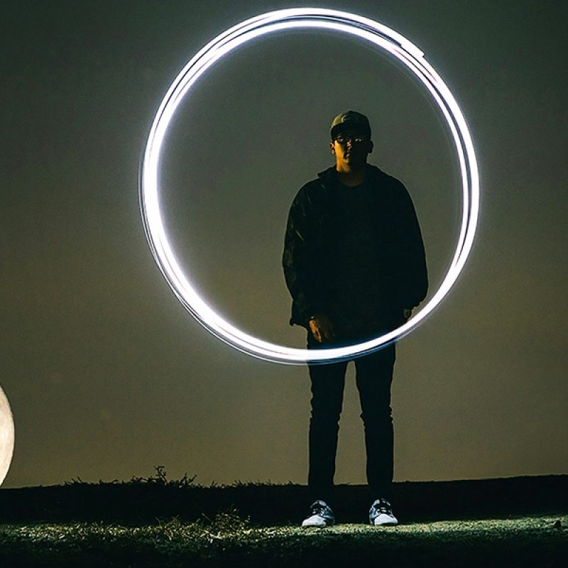 person drawing a circle with light in the dark.