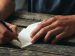 hand writing a note onto a piece of paper.