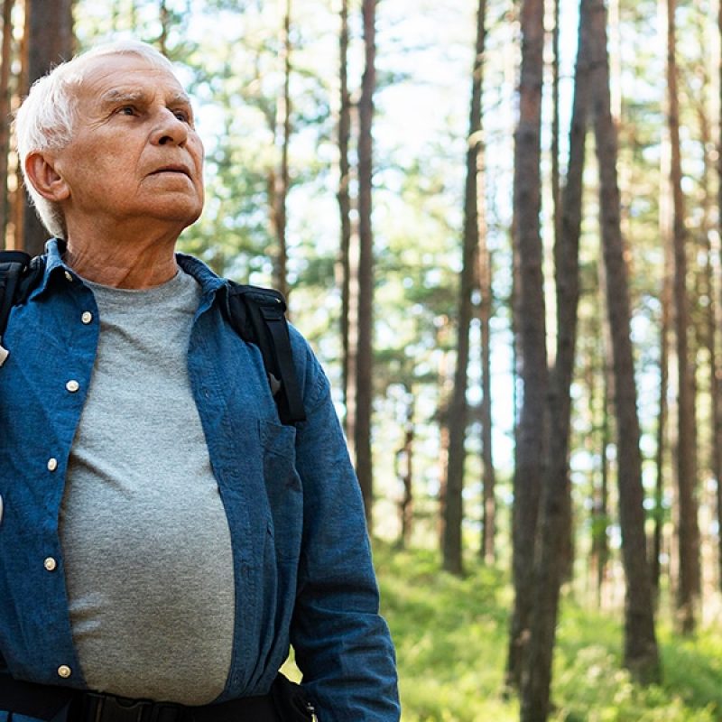 Older person walking outside in a forest