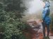 woman walking on a messy, muddy path.