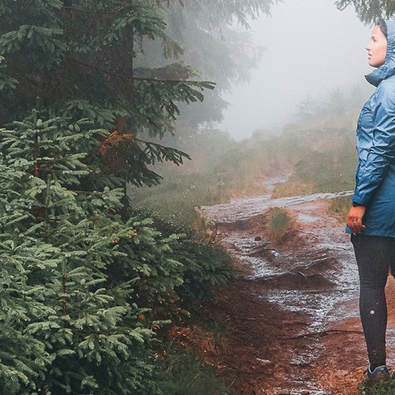 woman walking on a messy, muddy path.