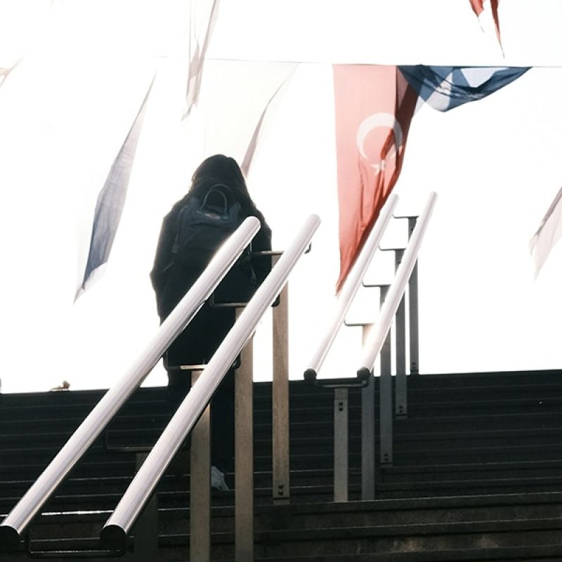 People walking up stairs in Istanbul, Turkey, being surrounded by Turkish flags.