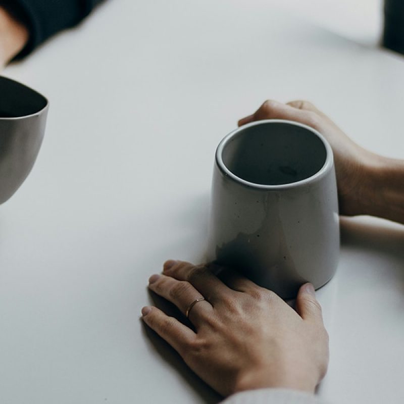 two people talking while drinking coffee
