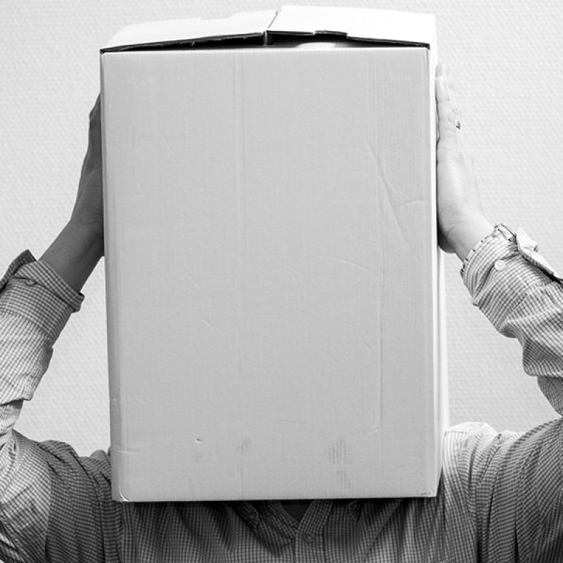 person holding a box over their head not being able to see in front of them.