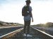 young person walking on train tracks during sunrise