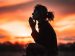 woman surrounded by peace praying during a sunset