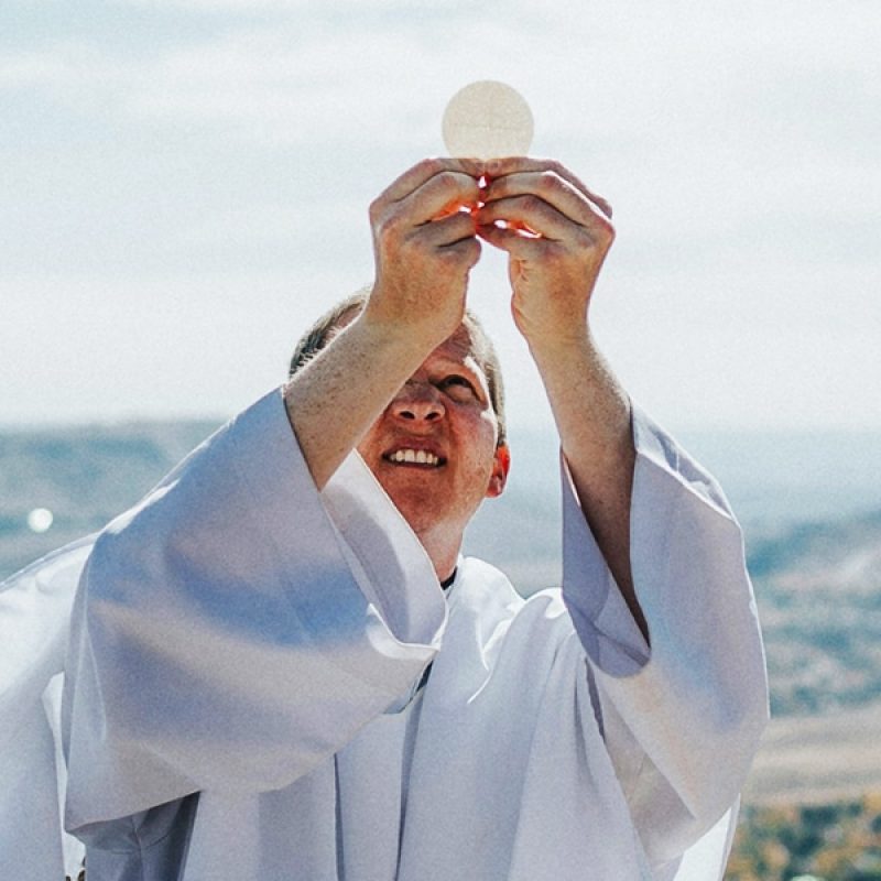 priest holding the sacramental bread to the sky.
