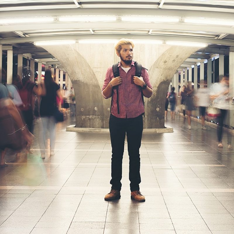 man standing still in rush hour.
