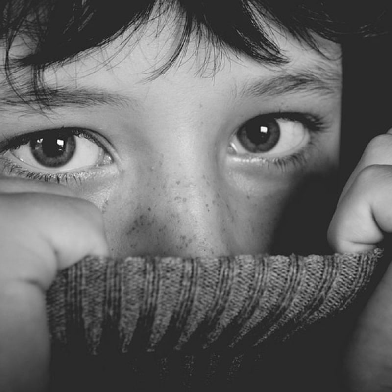 Girl peeking out from sweater pulled up around neck