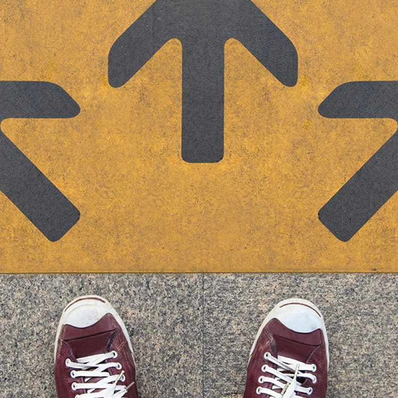 feet in sneakers in front of three arrows