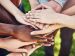 group of people stacking their hands as a sign of solidarity and teamwork