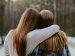 Two women friends embracing, one comforting the other.