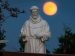 A hunter's moon rises behind a statue of St. Francis of Assisi on the grounds of the National Shrine of Our Lady of Champion in Champion, Wisconsin.