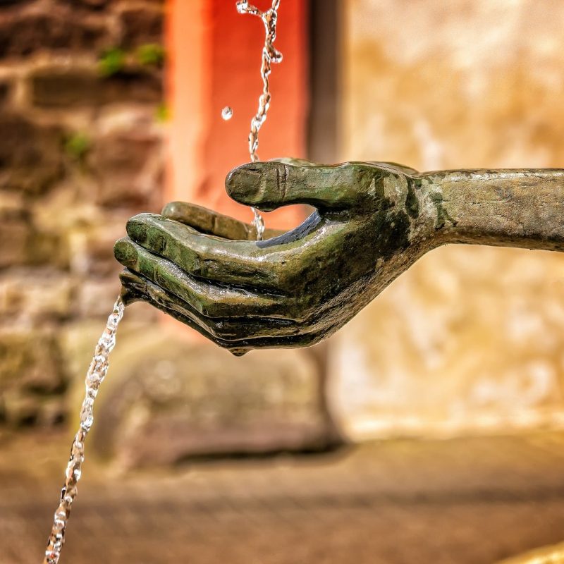 statue of a hand and water