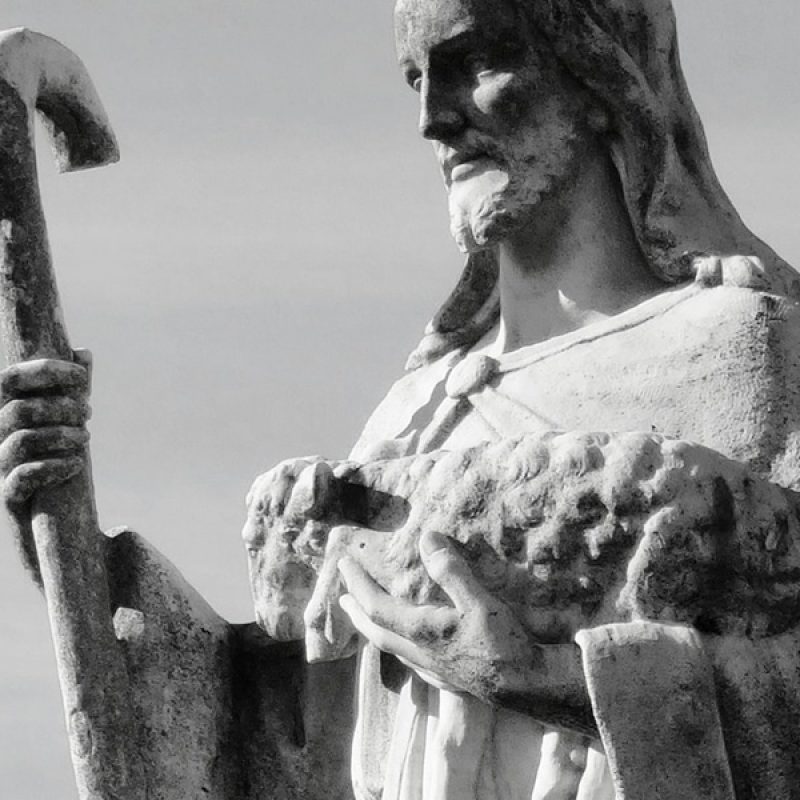 statue of Jesus as shepherd holding a staff and a lamb.