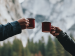 two arms with red coffee mugs