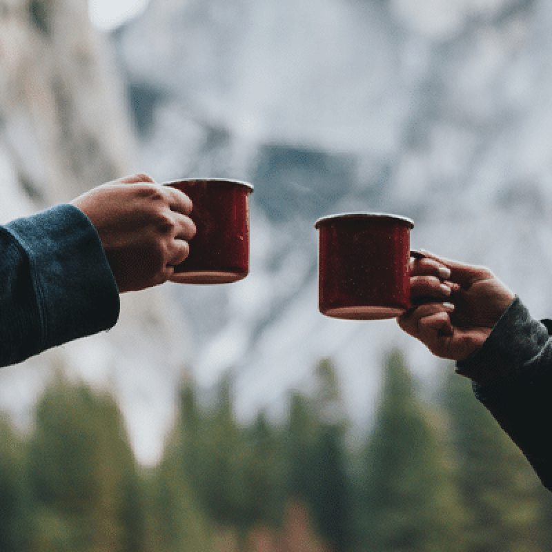 two arms with red coffee mugs