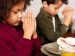 Two kids praying with folded hands before meal