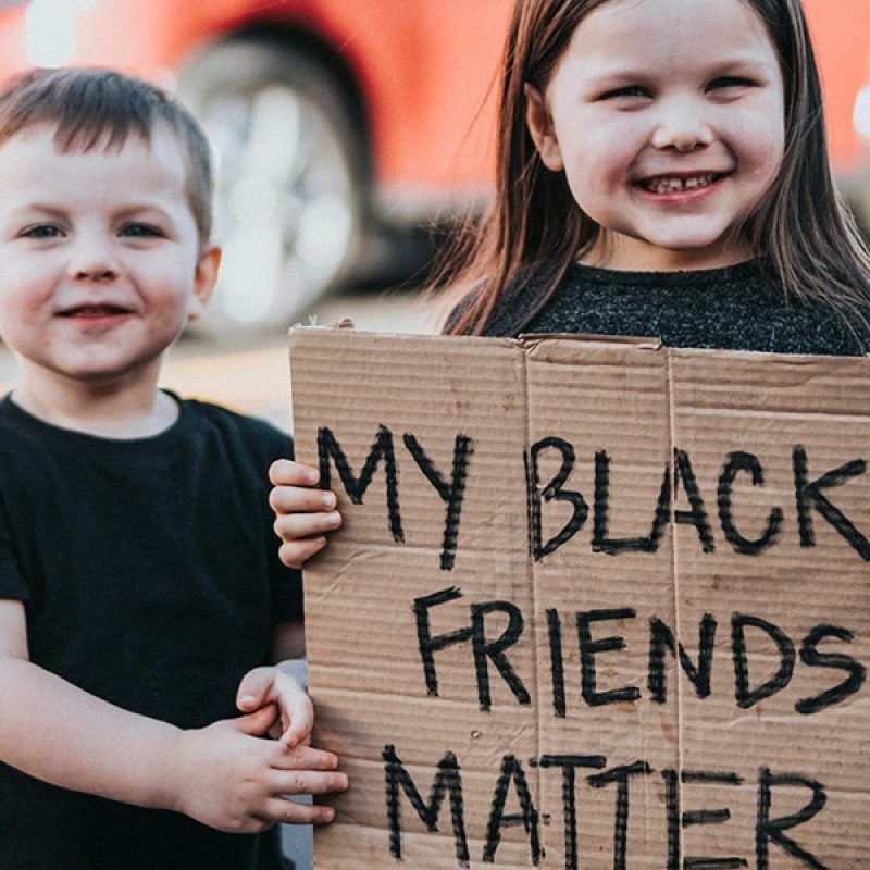 two kids holding a sign with the words: "My Black Friends Matter".