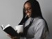 Young woman enjoys reading a book while drinking coffee