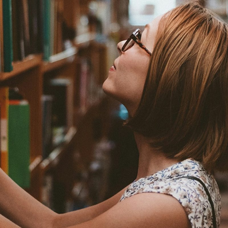 woman looking for a book in the library