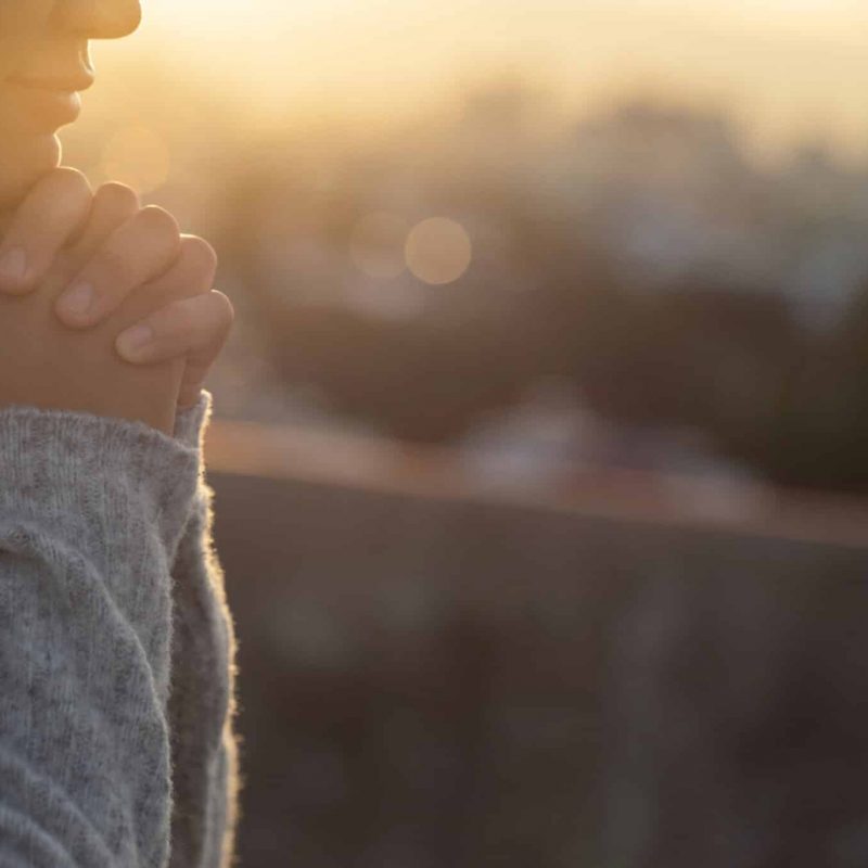 Women raise their hands to ask for blessing from God.