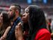 A woman prays as thousands gather at a memorial service for slain conservative activist Charlie Kirk at State Farm Stadium in Glendale, Ariz., Sept. 21, 2025.