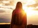 woman bathed in bright sunlight looking into the distance.