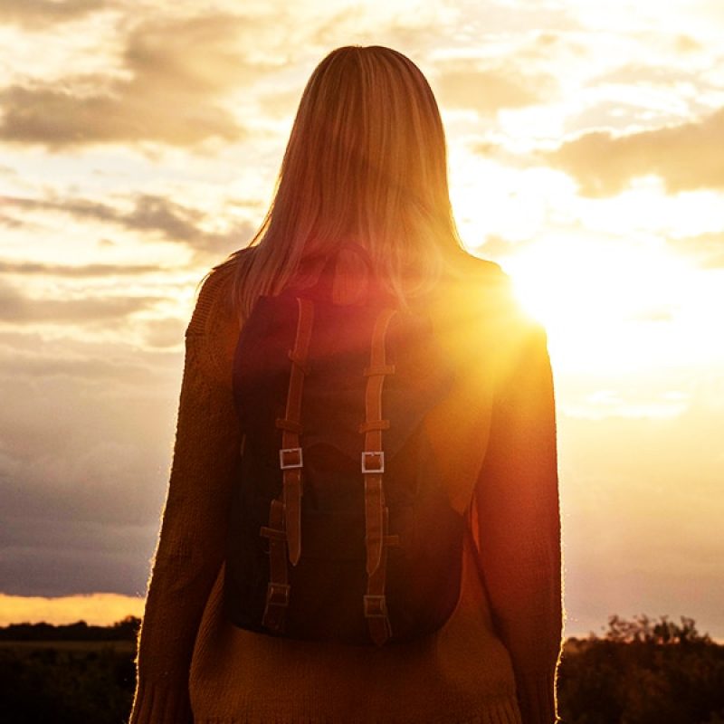 woman bathed in bright sunlight looking into the distance.