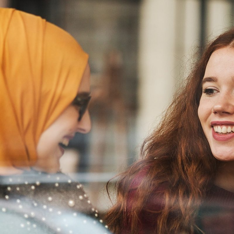 two young diverse woman talking