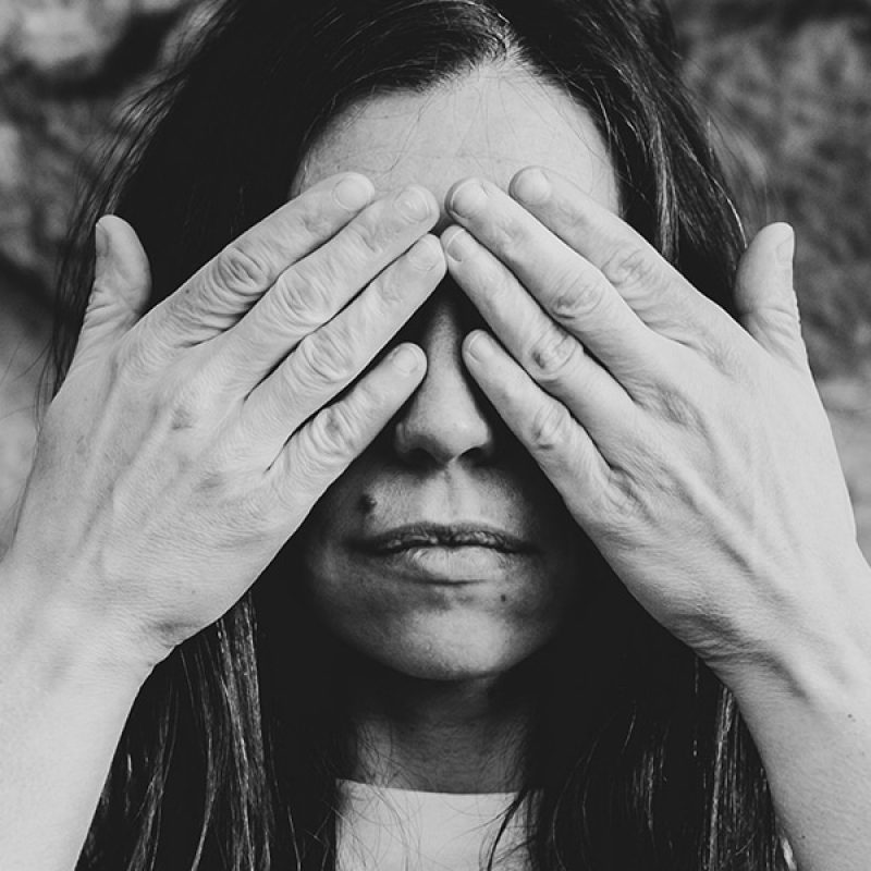 woman covering her eyes with her hands.