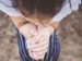 woman with folded hands praying.