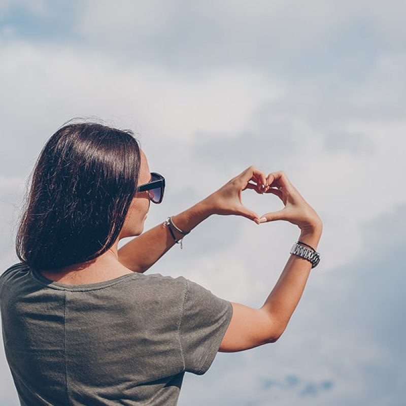 woman forming a heart with her hands.
