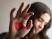 sad woman with a broken heart drawn on her hand