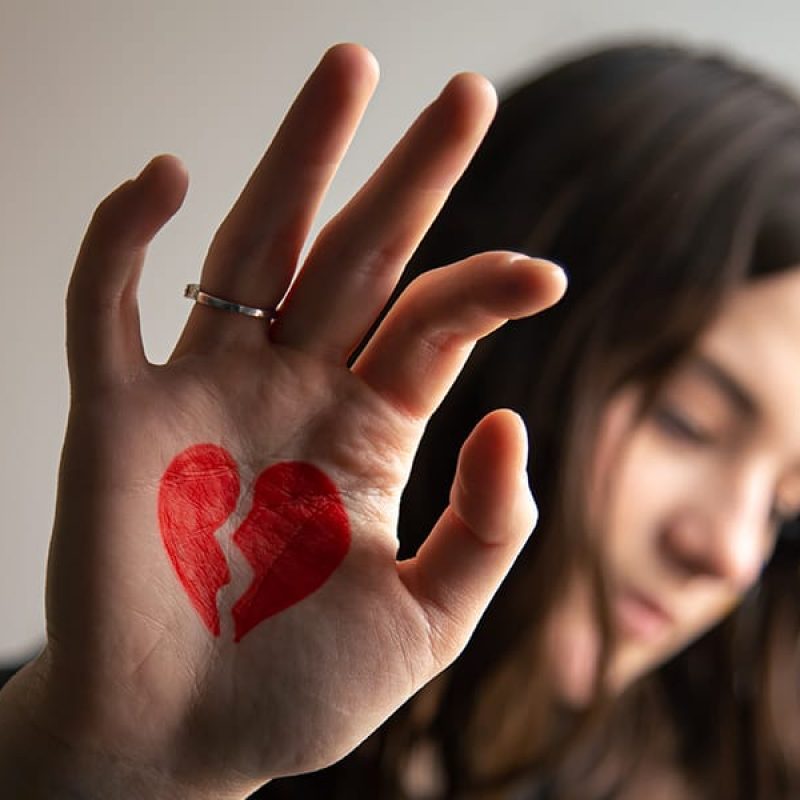 sad woman with a broken heart drawn on her hand