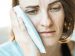 woman holding a icepack agains her painful head.
