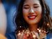 woman praying while holding lights in her hands