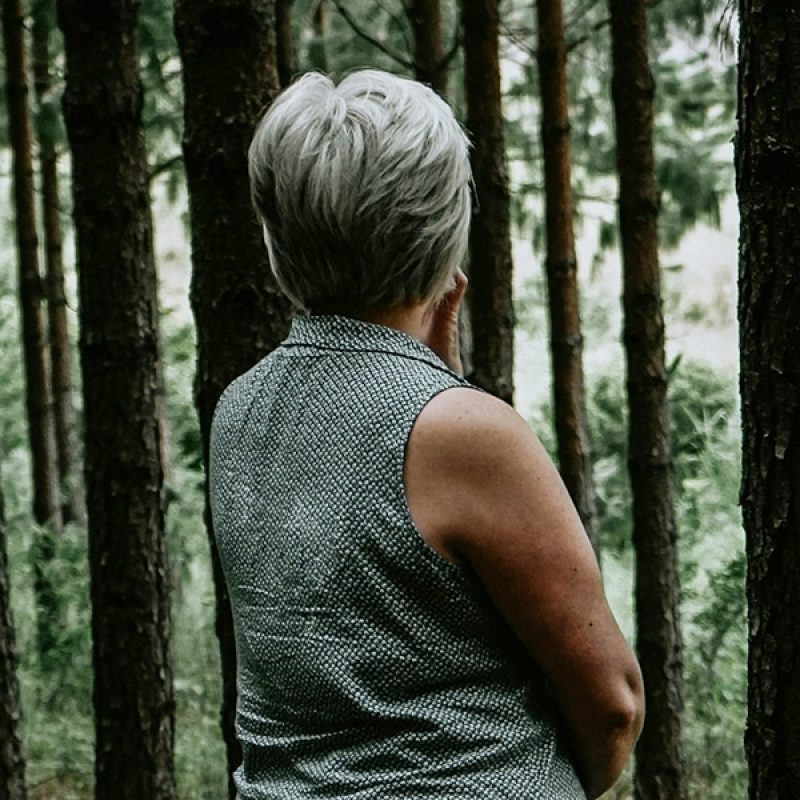 woman standing in a forest and listening to the quietness