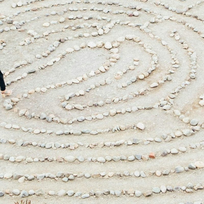 woman walking through a maze made out of stones.
