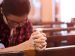 woman praying at a parish.