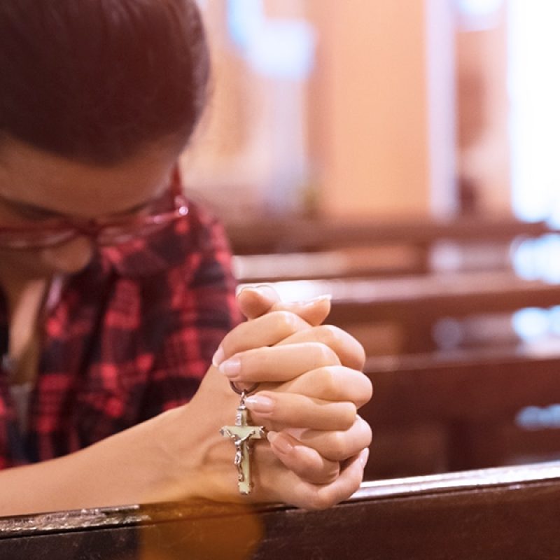 woman praying at a parish.