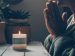 woman_praying_candle woman praying with folded hands in front of a candle