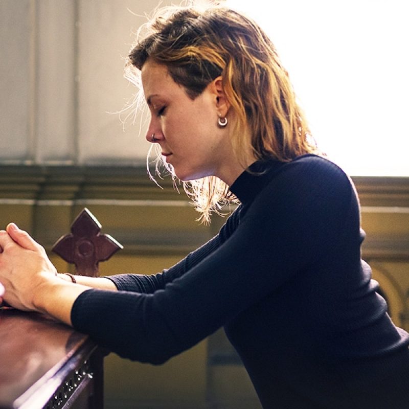 woman praying in chapel