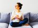 woman sitting on a couch reading a book in a minimalist room.