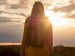 woman reflecting while watching a sunset